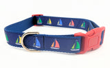 Sailboat dog collar made from navy blue nylon webbing with yellow, green, and red sailboat ribbon. Features a red plastic side-release buckle and navy blue nylon webbing.