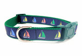 Sailboat dog collar made from navy blue nylon webbing with yellow, green, and red sailboat ribbon. Features a green plastic side-release buckle and green nylon webbing.