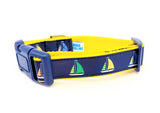 Sailboat dog collar made from navy blue nylon webbing with yellow, green, and red sailboat ribbon. Features a navy blue plastic side-release buckle and yellow nylon webbing.