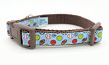 All-Star Sports Ball dog collar featuring baseball, basketball, football, soccer, tennis, and volleyball on a light blue ribbon with a brown plastic buckle.