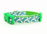 Dog collar featuring seafoam green cartoon T-Rex dinosaurs on a white ribbon, sewn onto lime green nylon webbing and with a lime green side-release buckle.