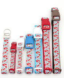Group of Winter Cardinal dog collars in various widths, including 5/8 inch and 1 inch sizes, showing the cardinal bird pattern scale. Also includes a key fob in the same design.