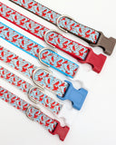 Group of Winter Cardinal dog collars in various widths, including 5/8 inch and 1 inch sizes, showing the cardinal bird pattern scale.