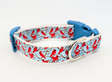 Handmade Winter Cardinal dog collar featuring red birds on snowy branches ribbon against a light blue nylon background.