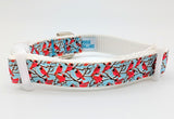 Handmade Winter Cardinal dog collar featuring red birds on snowy branches ribbon against a light blue nylon background.