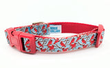 Handmade Winter Cardinal dog collar featuring red birds on snowy branches ribbon against a light blue nylon background.